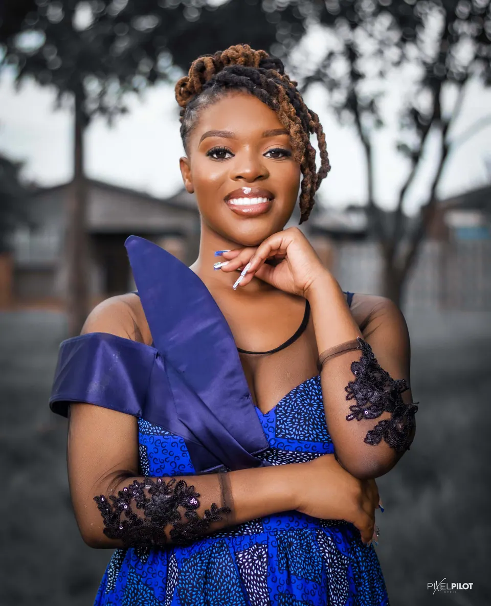 Woman in a blue African-print dress on a street, full-length portrait